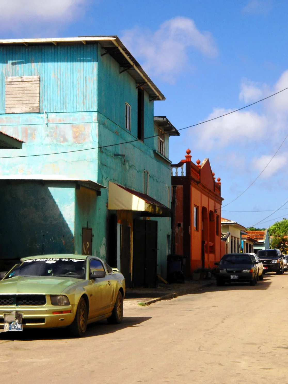 Colourful houses and parked cars on a residential street in Oranjestad