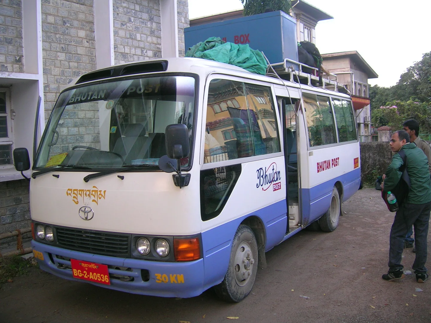 Bhutan Post passenger bus parked beside buildings
