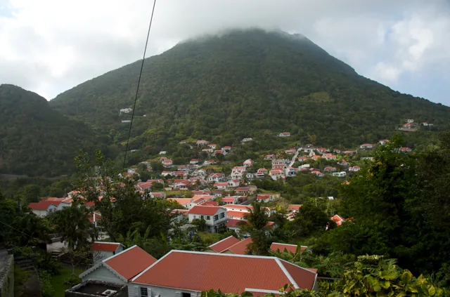 Red-roofed village houses below green Mount Scenery on Saba