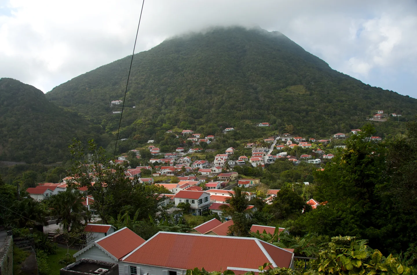 Red-roofed village houses below green Mount Scenery on Saba