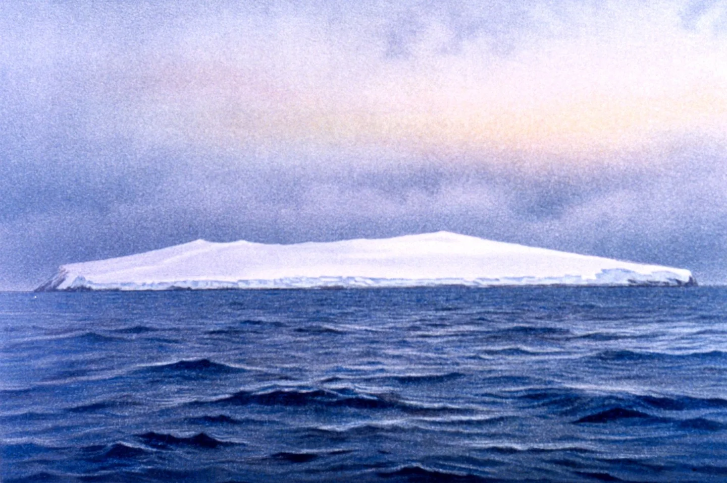 Hand-coloured historical photograph of Bouvet Island’s southeast coast viewed at sunrise