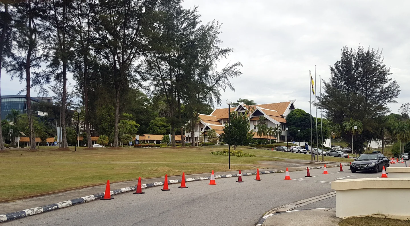 Universiti Brunei Darussalam administration building beside palms and a landscaped lawn
