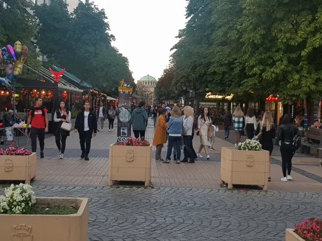 People walking along Sofia's Vitosha Boulevard between shops and street cafes