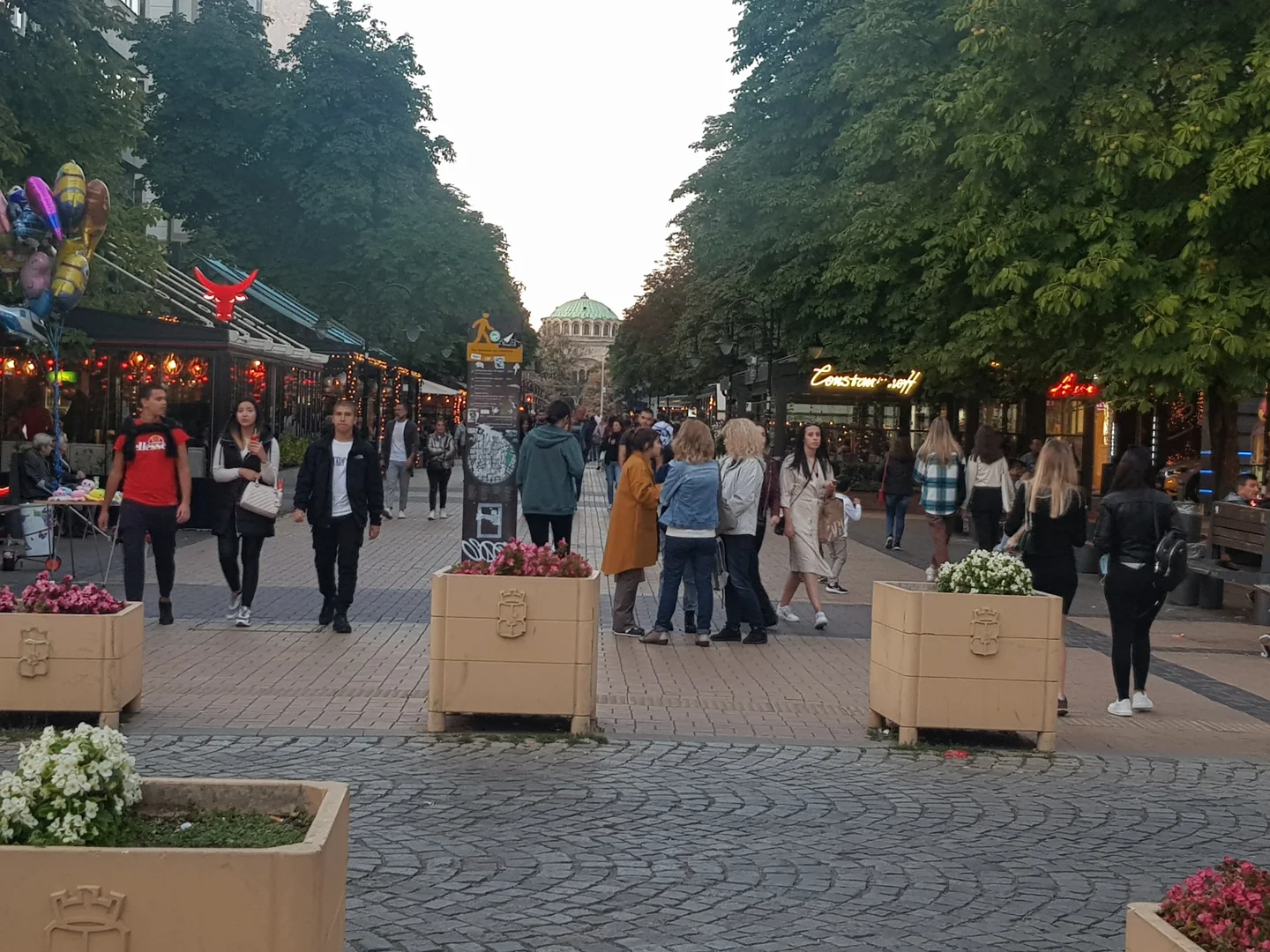 People walking along Sofia's Vitosha Boulevard between shops and street cafes