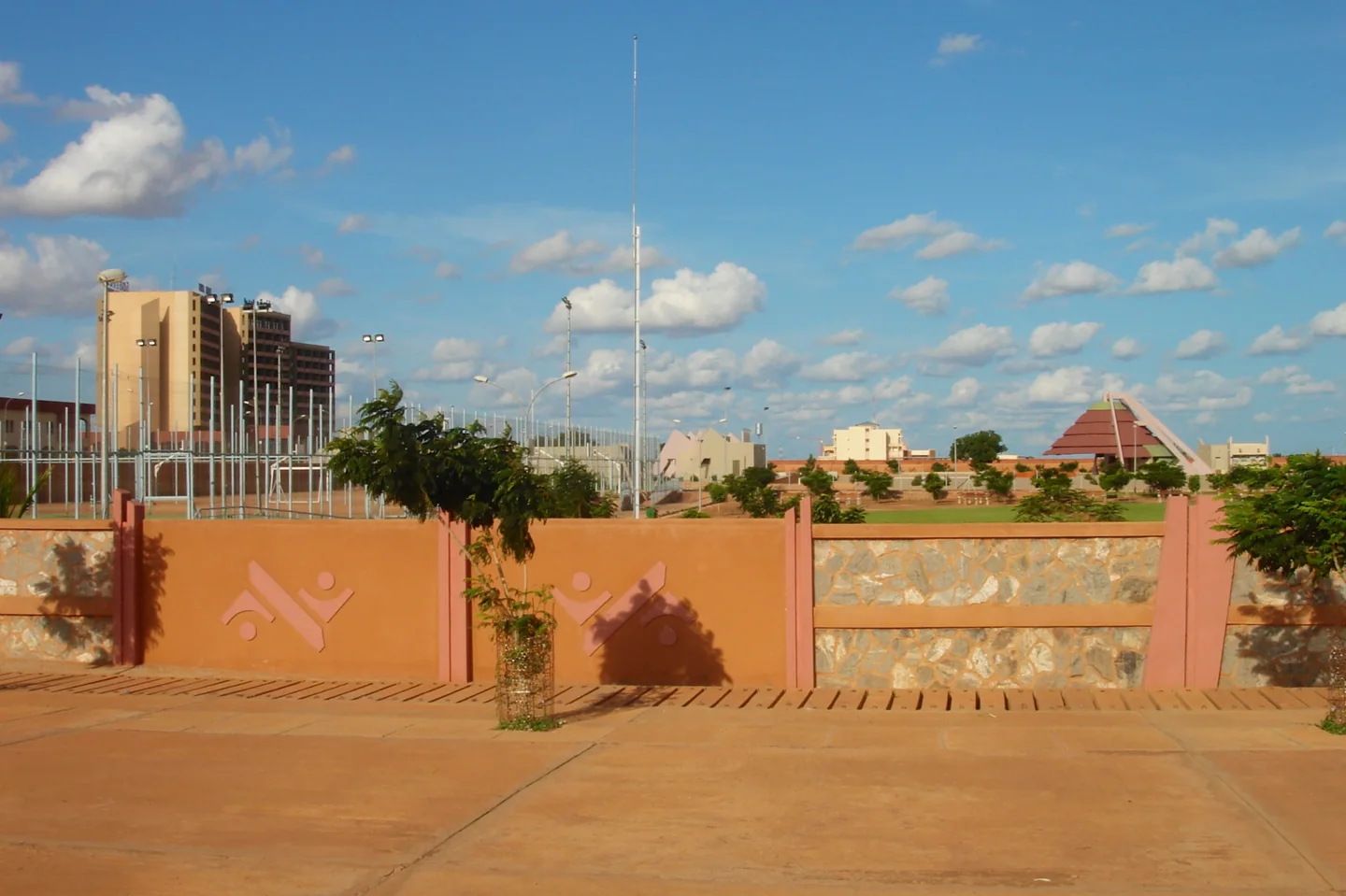 A decorative wall, a hotel and a triangular monument in Ouaga 2000