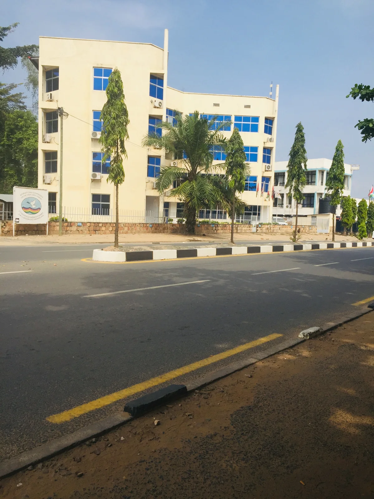 Paved Boulevard du Japon with a median and cream-coloured buildings in Bujumbura