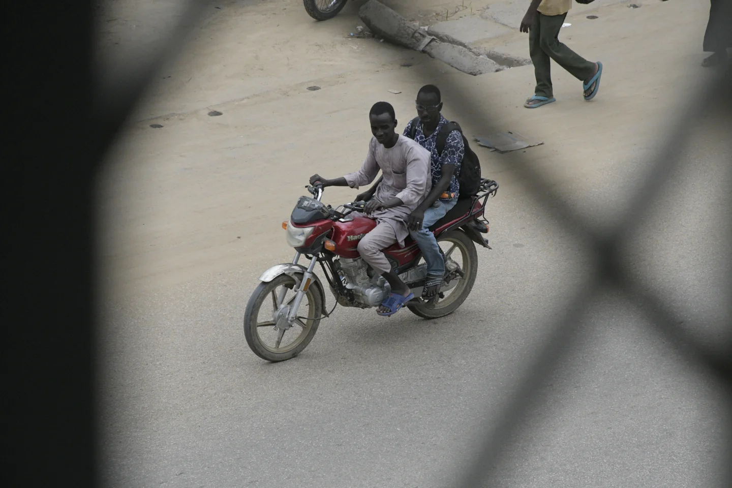 Two people on a motorcycle on a street in N'Djamena