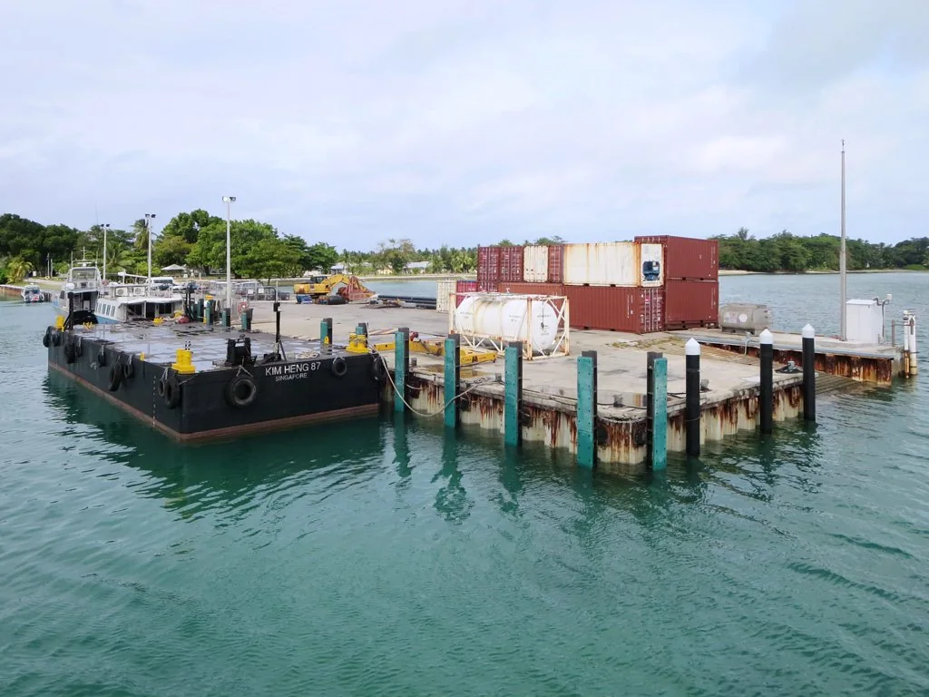 Home Island jetty extending over the lagoon with freight containers nearby