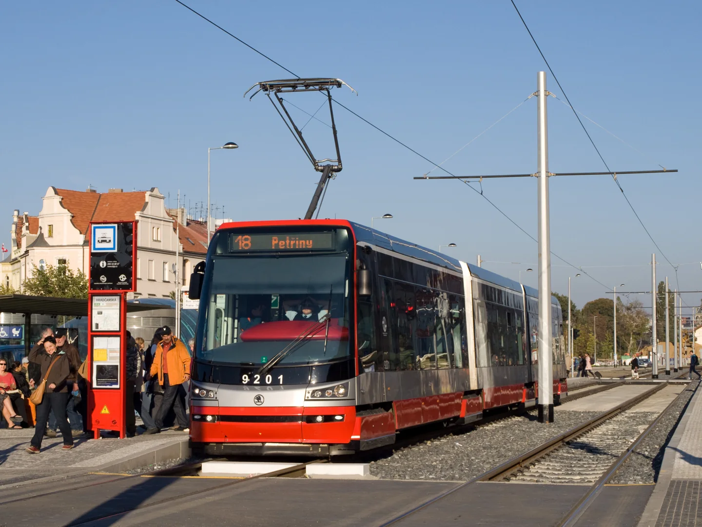 Red and white Škoda tram waiting at the Hradčanská stop in Prague